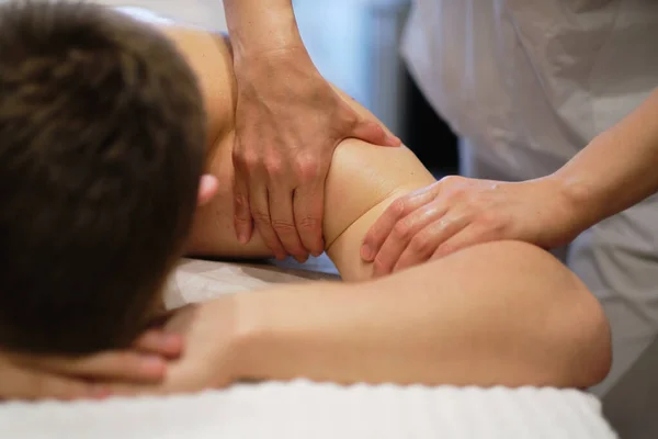 Primer plano del hombre disfrutando en relajantes hombros masaje. Hombre relajante en mesa de masaje recibiendo masaje — Foto de Stock