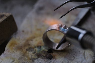Makro atış. Profesyonel aletlerle mücevher yapımı. El yapımı kuyumcu, mücevher üretimi. Eriyen metal