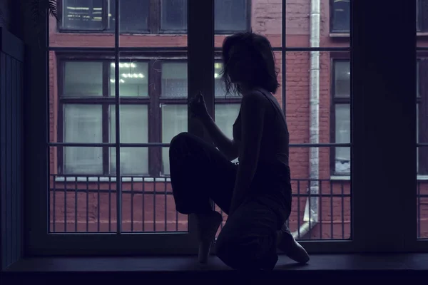 Tanečnice v okenním rámu ve staré budově. Mladá, elegantní, půvabná baletka — Stock fotografie
