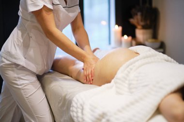 Masör spa salonundaki genç bayana antielülit masajı yapıyor. Vücut bakımı konsepti. Özel anti-elülit tedavisi.
