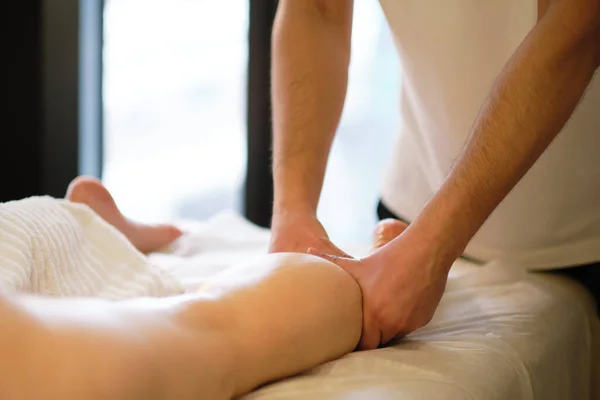 Detalle de las manos masajeando el músculo de la pantorrilla humana.Terapeuta aplicando presión sobre la pierna femenina. Manos de masajista terapeuta masajeando piernas de mujer joven en el salón de spa. Cuidado corporal en el salón de spa para mujer joven. —  Fotos de Stock