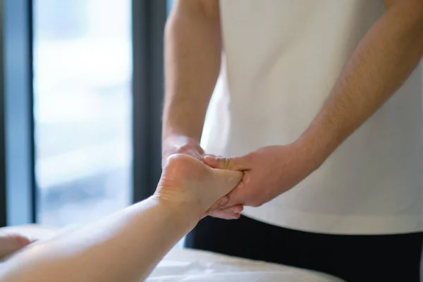 Ontspannende massage op de voet in spa salon binnen. — Stockfoto