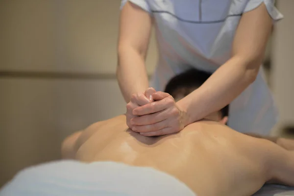 Close-up de homem desfrutando na massagem relaxante ombros. Homem relaxante na mesa de massagem recebendo massagem — Fotografia de Stock