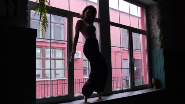 Silueta ženy tančící na pozadí velkého okna. — Stock video