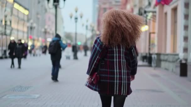 Krásná mladá stylová žena procházející se po ulicích města. sama ve velkém městě. koncepce osamělosti — Stock video
