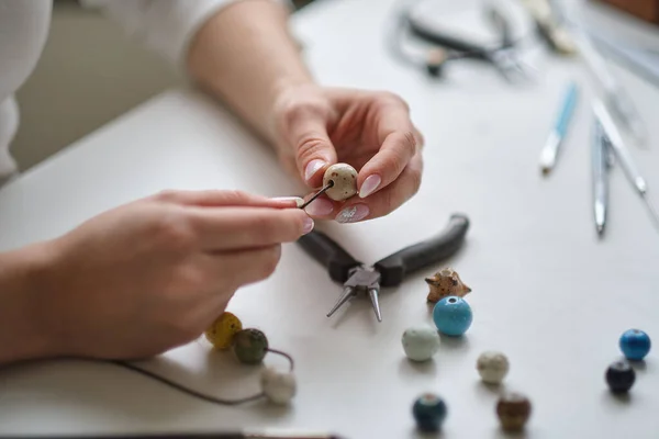 Wykonywanie biżuterii z profesjonalnych narzędzi. Projektant biżuterii pracuje w studio z narzędziami do robienia kolczyków. Zbliżenie żeńskich dłoni pracujących z narzędziami jubilerskimi — Zdjęcie stockowe