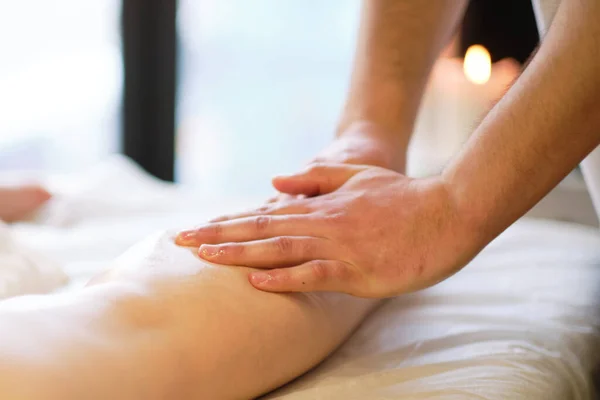 Detalle de las manos masajeando el músculo de la pantorrilla humana.Terapeuta aplicando presión sobre la pierna femenina. Manos de masajista terapeuta masajeando piernas de mujer joven en el salón de spa. Cuidado corporal en el salón de spa para mujer joven. — Foto de Stock