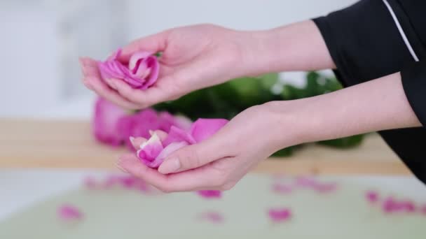 Kvinnliga händer häller rosenblad i badet. Lyx vit marmor Badrum Flödesvatten till badkar med rosa ros. Romantisk helg på hotell. Slow motion-video. Högkvalitativa 4k-stockar. — Stockvideo