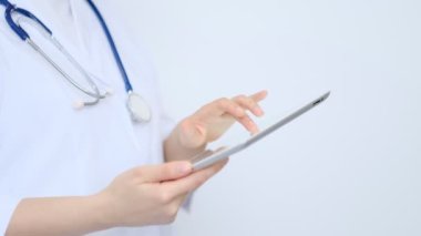 Modern dijital tablet kullanan beyaz önlüklü kadın doktor. Çevrimiçi tıbbi, sağlık veya tıbbi ağ konsepti. Tablet bilgisayar kullanan doktorun elleri