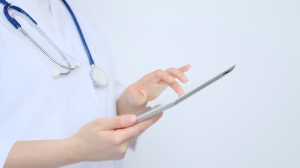 흰 가운을 입고 현대 디지털 태블릿 pc 를 사용하는 여성 의사. 온라인 의료, 건강 또는 의료 네트워크 개념. 태블릿 컴퓨터를 사용하는 의사의 손 — 비디오