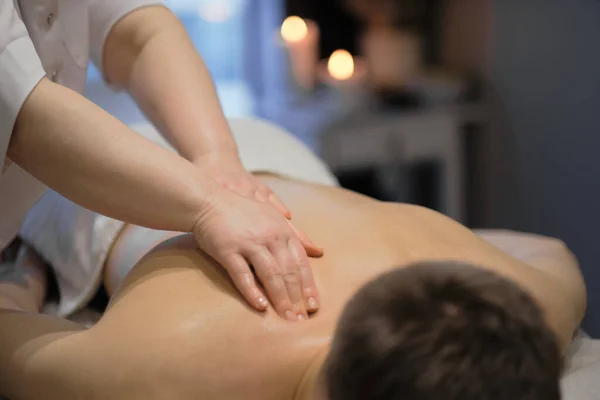 Primer plano del hombre disfrutando en relajante masaje de espalda. Hombre relajante en mesa de masaje recibiendo masaje —  Fotos de Stock