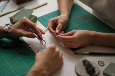 İki çağdaş mücevher atölyesinde birlikte çalışıyor. Usta ve çırak. Genç erkek asistan ve bayan kuyumcu kuyumcu atölyesinde birlikte çalışıyorlar..