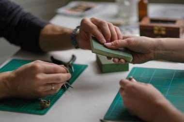 İki çağdaş mücevher atölyesinde birlikte çalışıyor. Usta ve çırak. Genç erkek asistan ve bayan kuyumcu kuyumcu atölyesinde birlikte çalışıyorlar..