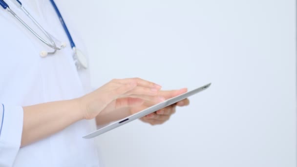 Ärztin im weißen Laborkittel mit modernem digitalen Tablet-PC. Online medizinisches, medizinisches oder medizinisches Netzwerkkonzept. Arzthände mit Tablet-Computer — Stockvideo