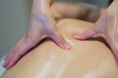 İnsanın sırt masajından zevk aldığı yakın çekim. Masaj masasında dinlenen adam masaj yaptırıyor.