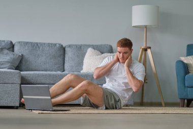 Evde kalırken kendine dikkat et. Spor eğitimi, evde dizüstü bilgisayarlı erkekler için esneme egzersizleri. Fitness minderinde yatan adam çevrimiçi yoga dersleri boş laptop ekranı