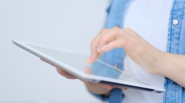 Bir tabletin ekranına parmağıyla işaret eden ve dokunan genç ve güzel kadının eline yaklaş. teknoloji, sosyal ağ, iletişim konsepti