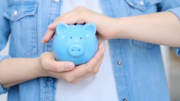 Concepto de ahorro. mujer desenfoque celebración de alcancía y monedas en el fondo de luz. Vista de cerca. Vídeo en cámara lenta. Material de archivo de alta calidad 4k. — Vídeo de stock