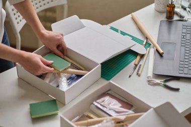 Tanınmayan kadın girişimci bir kutuda mal topluyor ve bir kurye şirketi aracılığıyla paket göndermek üzere. servis hizmeti kavramı