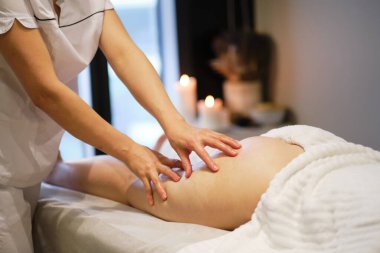 Masör spa salonundaki genç bayana antielülit masajı yapıyor. Vücut bakımı konsepti. Özel anti-elülit tedavisi.