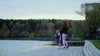 Mutlu anne kızıyla birlikte sonbahar parkında yürüyor. Aile sonbahar parkında yürüyor. Mutlu çocukluk kavramı.
