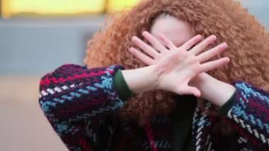 Güzel genç bir kadın kameraya bakıyor ve neşeyle gülümsüyor. Gün ışığında sokakta gülen surat. Dışarıda olumlu bir portre var. Kapatın. Yavaş çekim videosu. depolama görüntüleri