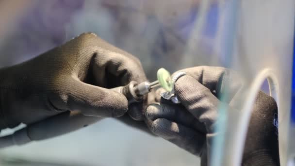 Mani da gioielliere che lavorano con un anello. Questo video mostra le mani del gioielliere che puliscono un anello con uno strumento rotante. — Video Stock