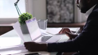 Rahatlamış işçiler işlerini bitirdikten sonra sıkı çalışma günlerinden sonra işi bırakırlar. Düşünceli Afro-Amerikan işadamı pencereden dışarı bakıyor ve ofis masasında oturuyor.