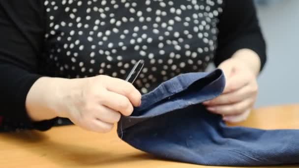 Elbise dikmek için tekstil işinde çalışan yetenekli bir kadın terzi. Dikiş işleminin görüntüsünü kapat. Işık bulanık arkaplan — Stok video
