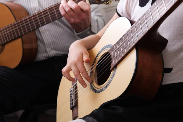 La petite fille et son père jouent de la guitare. Apprendre à jouer de la guitare. Enseignement de la musique et leçons parascolaires. — Photo