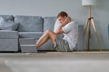 Neşeli adam sabahları evde jimnastik yapıyor yoga minderinde oturup esniyor, fotokopi çekiyor. Evde Eğitim.