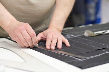 Terzi kadın işyeri. Terzi kadın, terzi stüdyosunda elbise dikmek için tebeşirle desen çiziyor. Terzi atölyesi, el yapımı özel elbiseler dikmek ve tamir etmek. yaratıcı meslek kavramı