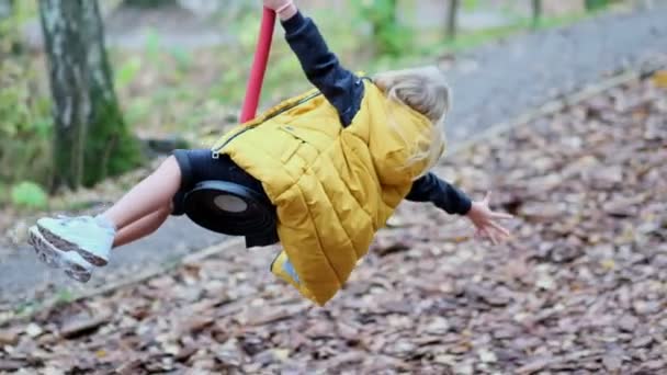 Little girl having fun outdoors. Zipline for kids. Slow motion footage. mom or nanny plays with her daughter on the playground. happy childhood concept. — Stock Video