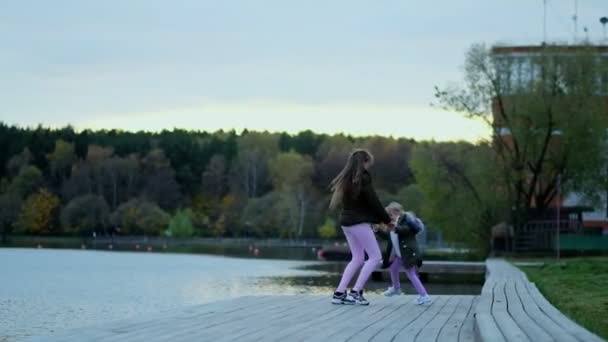 Happy mom walks with her daughter in the autumn park. The family is walking in the autumn park. happy childhood concept. — Stock Video