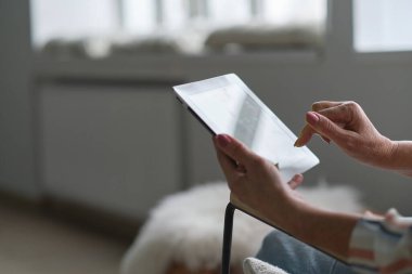 Evde dijital tablet kullanan yaşlı Hintli kadın. Büyükannem torunlarına ya da arkadaşlarına video görüşmeleri yapıyor.