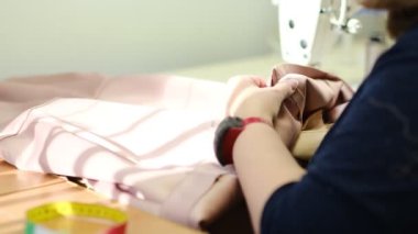 İş yerindeki profesyonel üretim makinesine kadın eli dikiş atıyor. Dikiş işleminin görüntüsünü kapat. Işık bulanık arkaplan