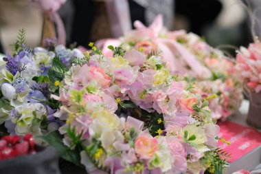 Dükkan sahibi, yerel bir zanaatkar pazarında elinde bir buket kurumuş çiçekle tezgahın arkasında satış yapıyor. Küçük bir iş. Genç bayan girişimci çiçek bayramı kompozisyonu satıyor..