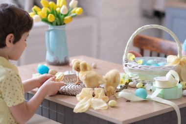 Anne ve oğul birlikte eğleniyor ve ziyafeti kutluyorlar. Aile Paskalya için hazırlanıyor. Little ve annem evi dekore ediyor. yumuşak odak