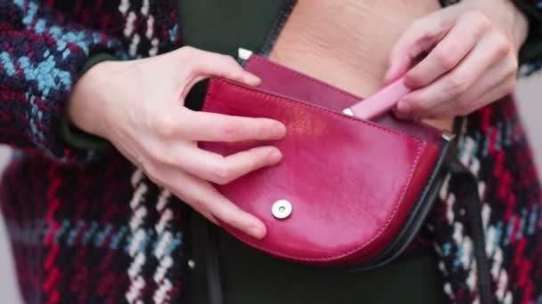 Buiten pakt een onherkenbare vrouwenhand lippenstift uit haar tas. Sluit maar af. Een slow motion video. voorraadbeelden — Stockvideo