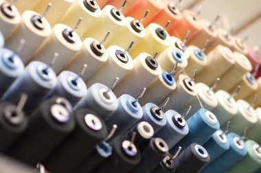 Skeins şeklinde dikiş iplikleri. Bir demet büyük renkli iplik makarası. Daha iyi bir atölye. Makaralara dikmek için renkli iplikler..