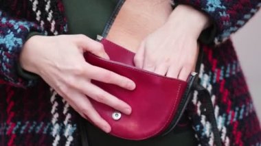 Dışarıda tanınmayan bir kadının eli çantasından ruj alıyor. Kapatın. Yavaş çekim videosu. depolama görüntüleri