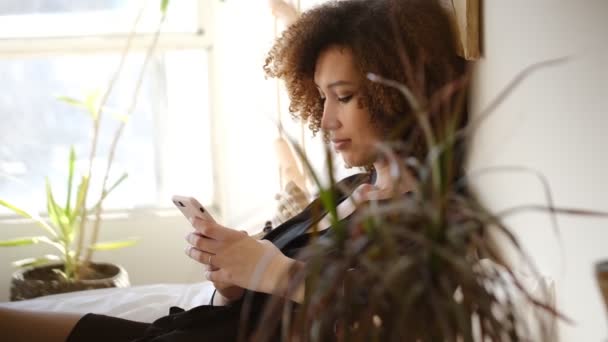 Giovane bella donna afro-americana che scrive su smartphone o guarda i social network — Video Stock