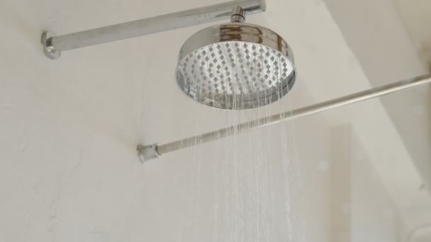 Sluiten van Water vloeien uit de douche in de badkamer interieur. stromend water van douchekraan. — Stockvideo