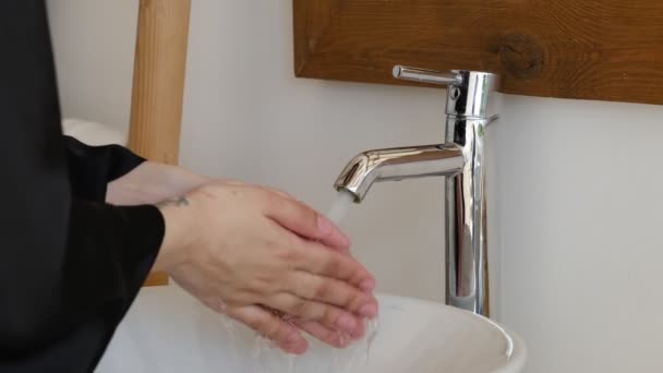 穿着黑色丝绸长袍的女人用泡沫肥皂和清水洗手。洗手，保持双手清洁，防止病毒传播 — 图库视频影像