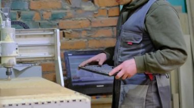 Tahta değirmeni. CNC 'deki ahşap panellerin işlenmesi koordine edilmiş marangozluk makineleri. Yavaş çekim videosu. Talaş farklı yönlere dağılır.