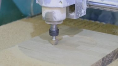 Tahta değirmeni. CNC 'deki ahşap panellerin işlenmesi koordine edilmiş marangozluk makineleri. Yavaş çekim videosu. Talaş farklı yönlere dağılır.