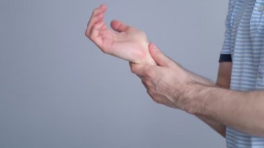 Adam kendini fırçasından tutar ve şiddetli bir acı hisseder. Erkek kolları, bilgisayar ve dizüstü bilgisayardaki uzun çalışmalardan kaynaklanan ağrılı bileğini tutuyor. Video kayıtları. Yavaş çekim