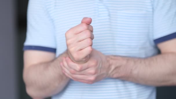 Un hombre masajea un porro en su mano. De cerca. Síndrome del túnel carpiano, artritis, concepto de enfermedad neurológica. Entumecimiento de la mano. material de video. Movimiento lento — Vídeo de stock