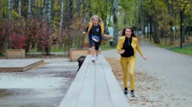 Mutlu zaman konsepti. Parkta kızının peşinden koşan mutlu genç anne. Video kayıtları. Yavaş çekim, yumuşak odaklanma