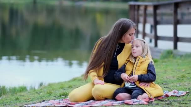亲吻和拥抱幸福的家庭。美丽的母亲和她的小女儿在户外。大自然。美丽的妈妈和她的孩子一起在公园里玩耍。视频库存镜头。慢动作软聚焦 — 图库视频影像
